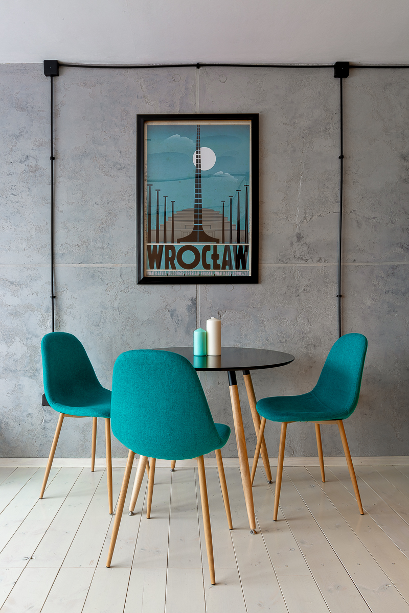 Okrągły stolik i plakat na betonowej ścianie - iglica Wrocław